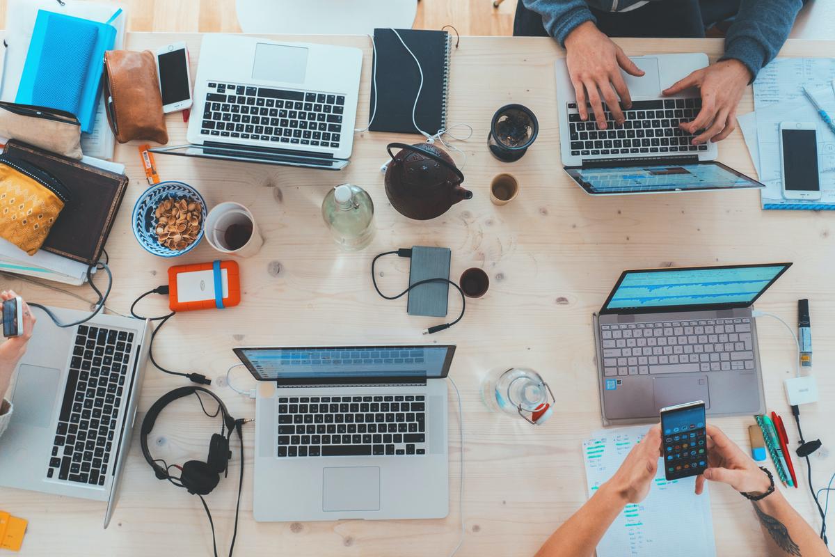 Image description: A group of diverse people working together on digital devices.