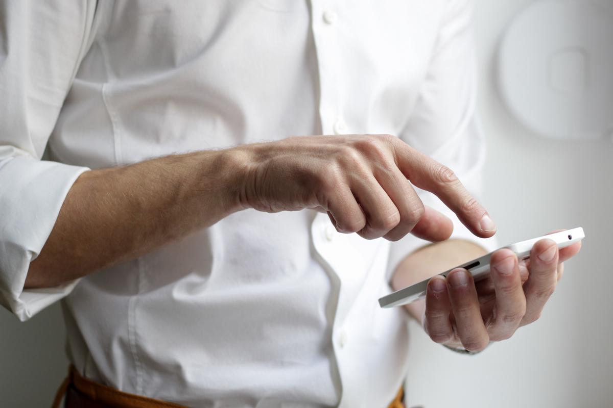 Image of a small business with employees using mobile devices for various tasks, emphasizing the importance of technology management.